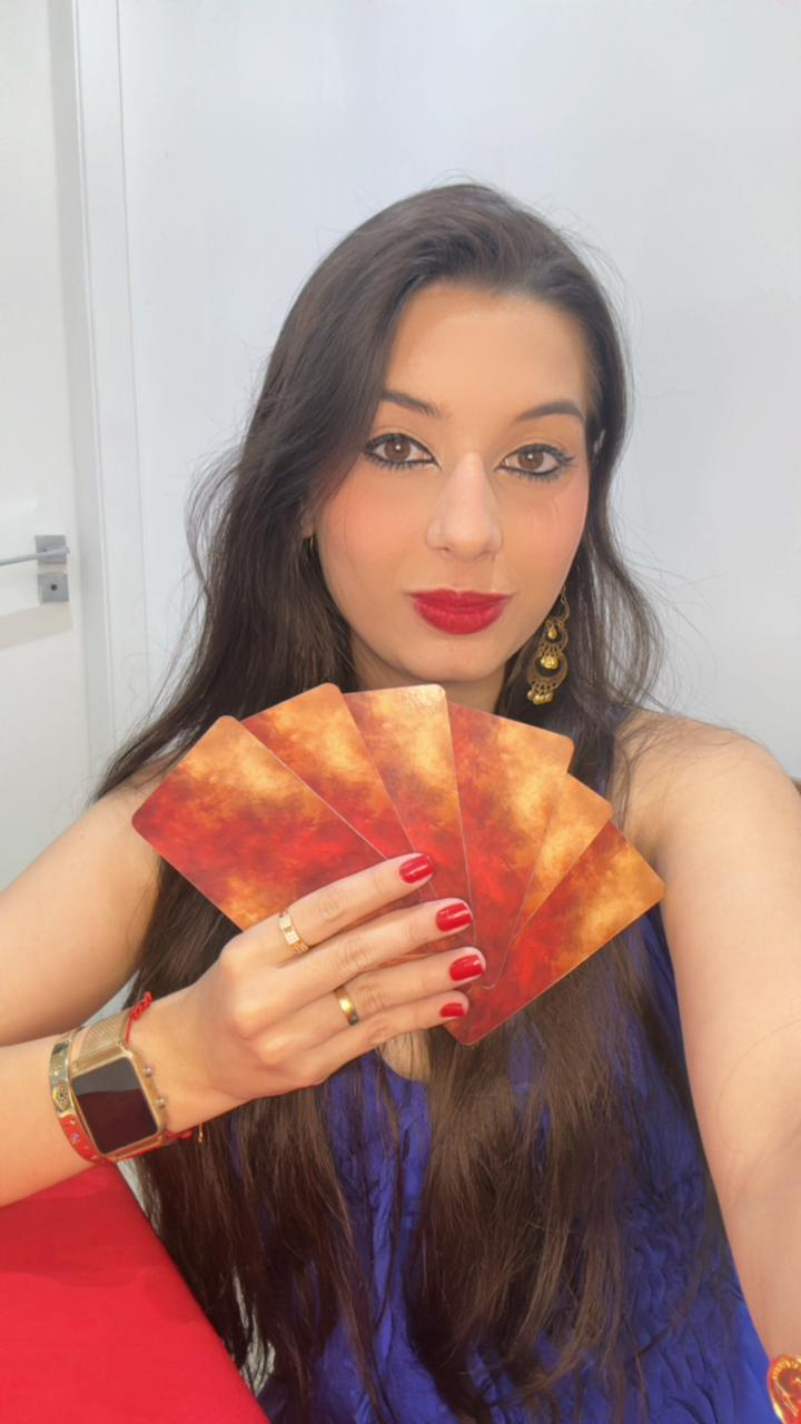 Mãe Camilly segurando as cartas de tarô